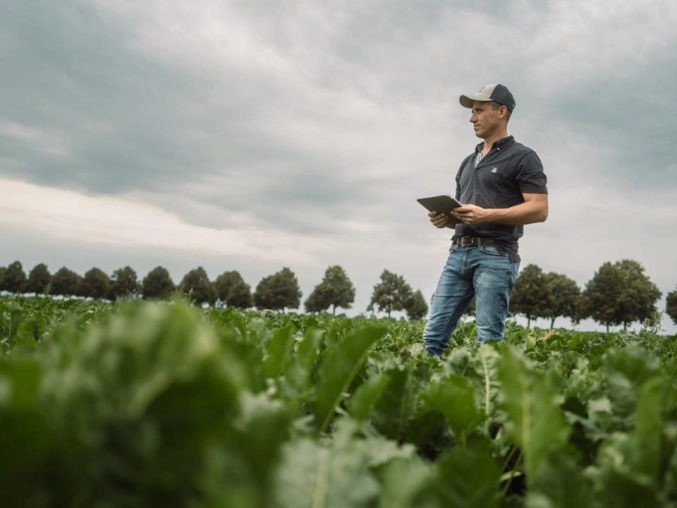 Farmer in a field on a ipad